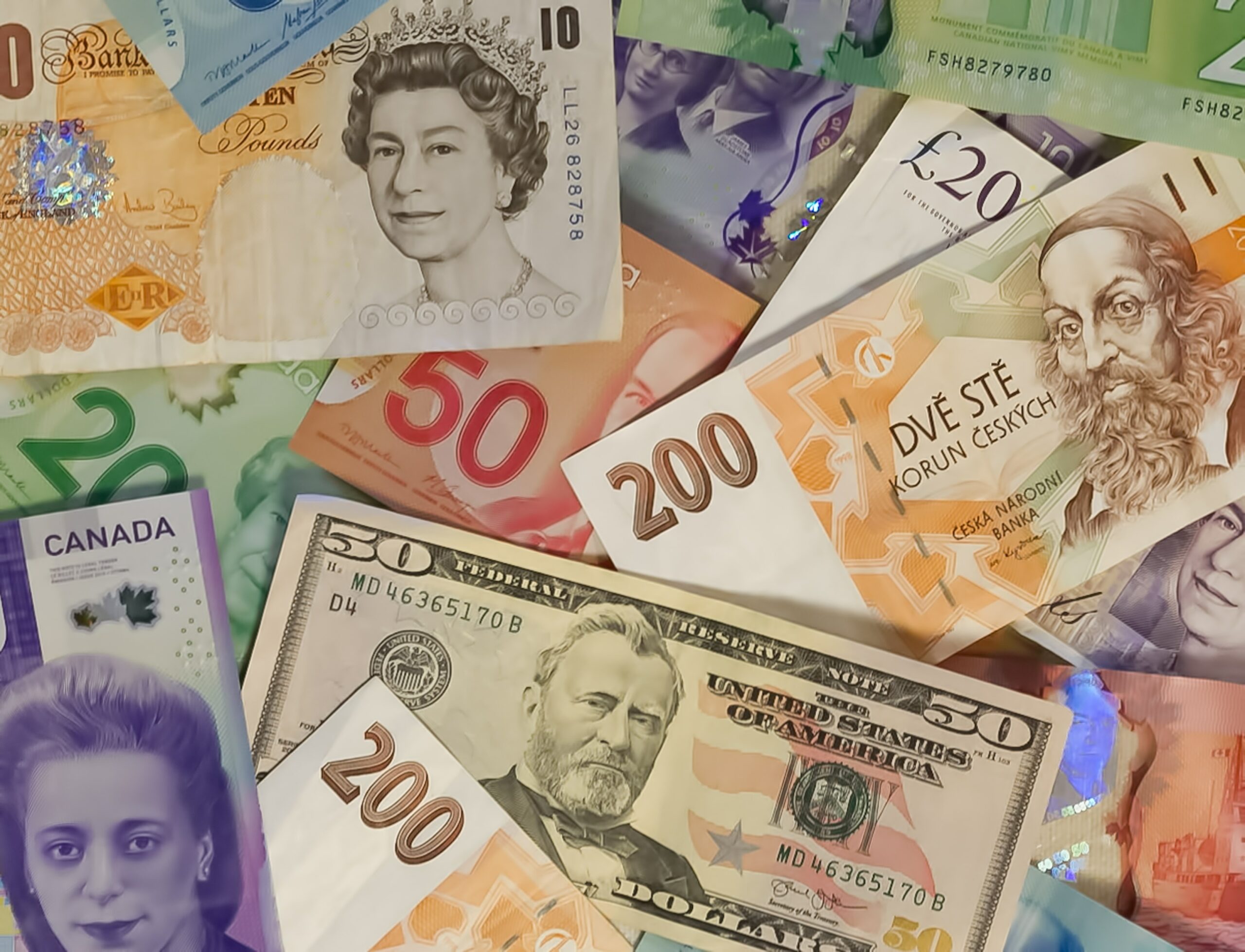 Viele Geldscheine in verschiedenen Währungen durcheinander auf- und nebeneinander
