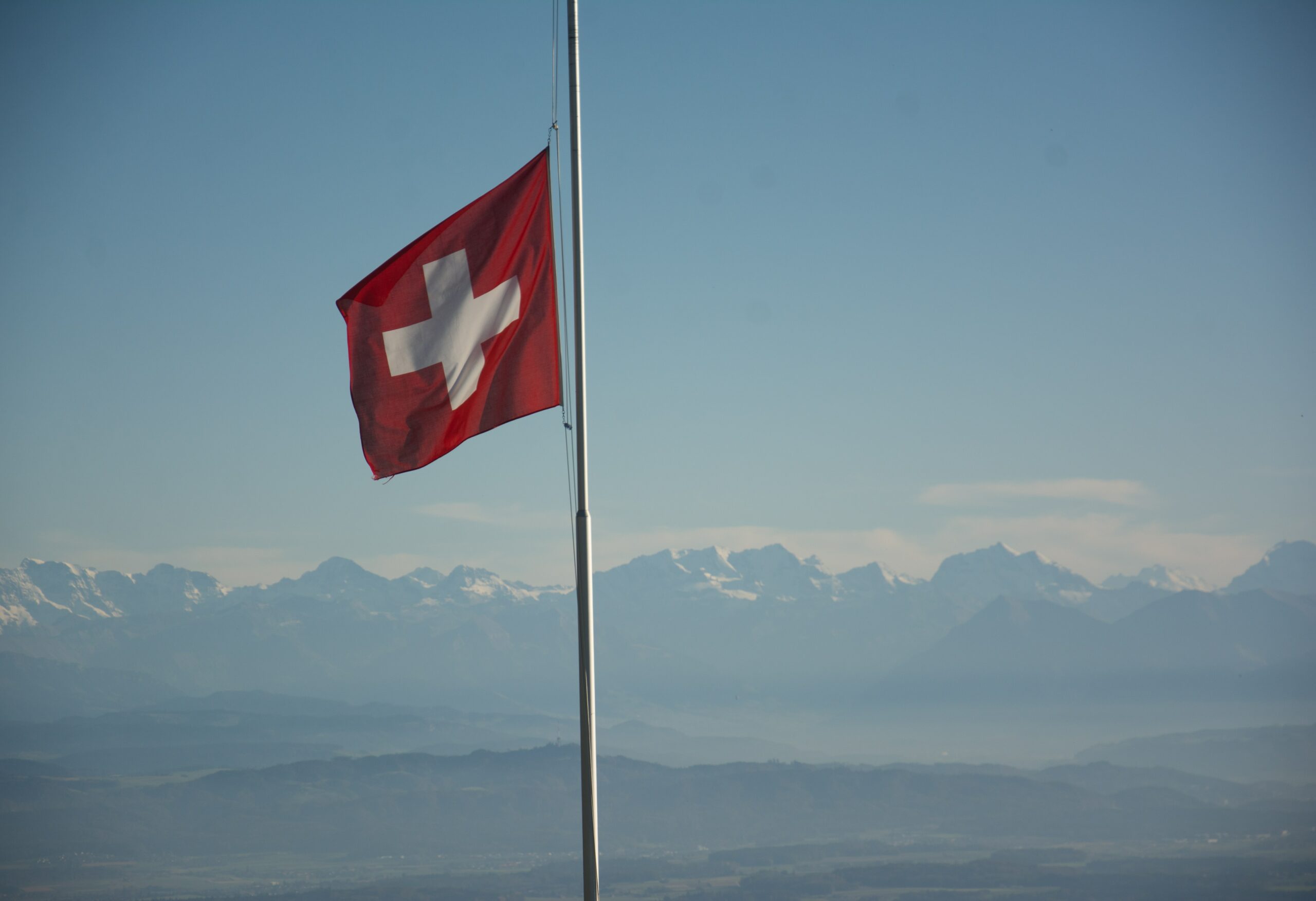 Schweizer Nationalflagge mit Alpen im Hintergrund