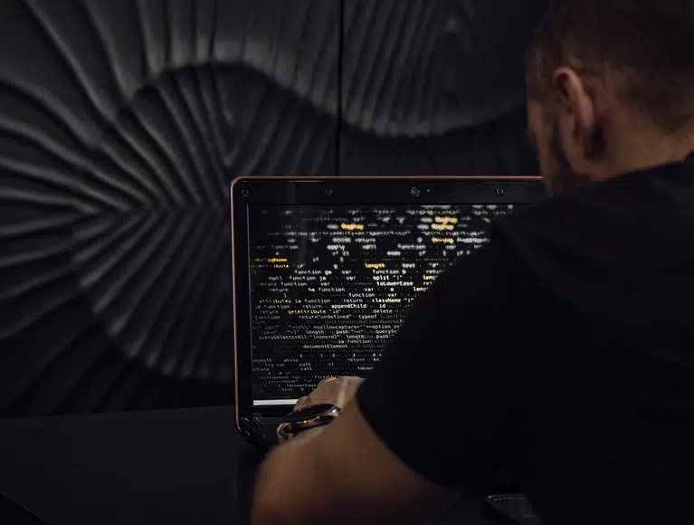 Mann sieht Code auf Laptop